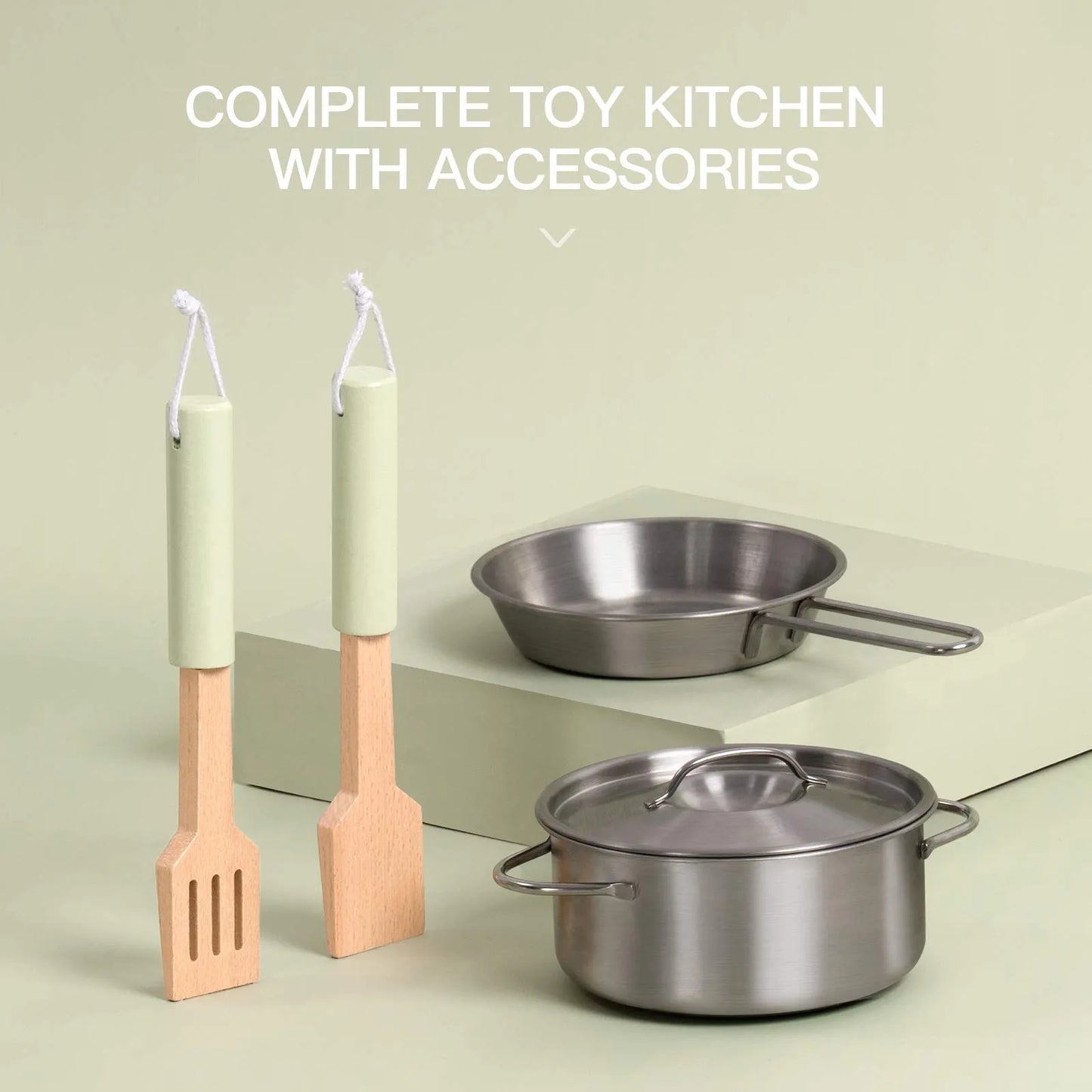 Toy kitchen set with pots, pans, and utensils on a light green background