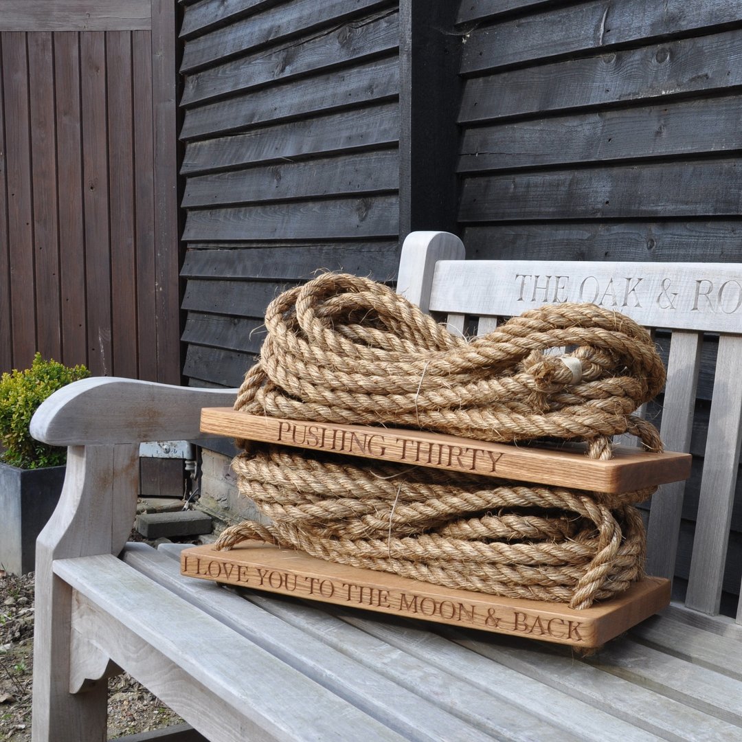 Oak and rope swing and engraved text on a bench outdoors