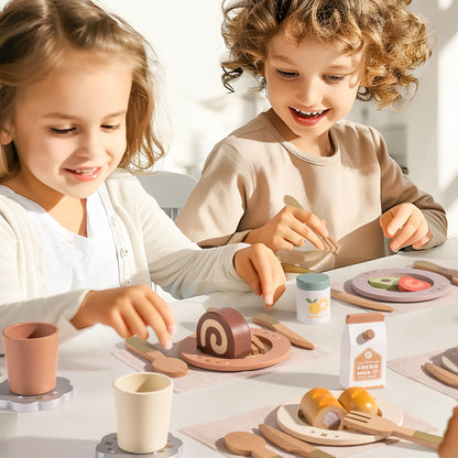 Two children playing with a toy kitchen set on a table. Wooden dinnerware play set for kids – ROBUD 29-piece set with plates, cups, and utensils with wooden play food