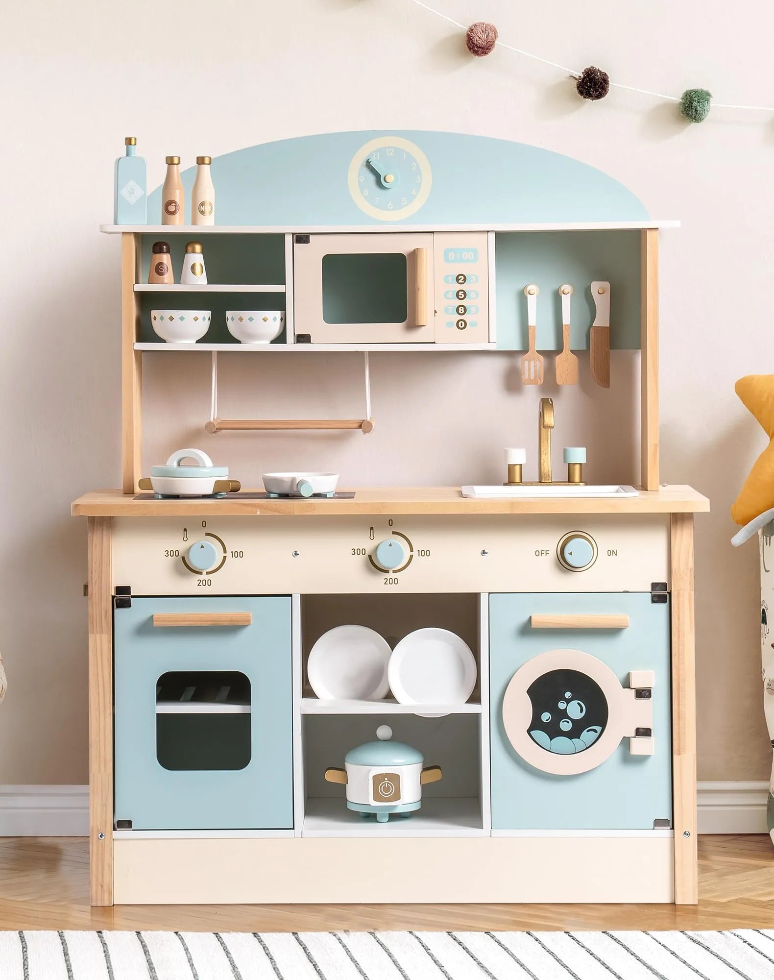 Children's play kitchen set with wooden cabinets and blue accents on a white floor.