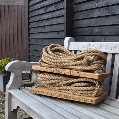 Oak and rope swing and engraved text on a bench outdoors